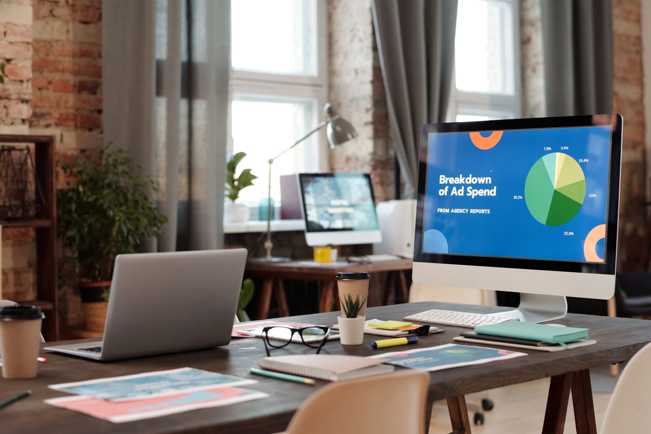 Un espace de travail de bureau moderne, avec des ordinateurs, des graphiques et du matériel de bureau, conçu pour favoriser un environnement productif.