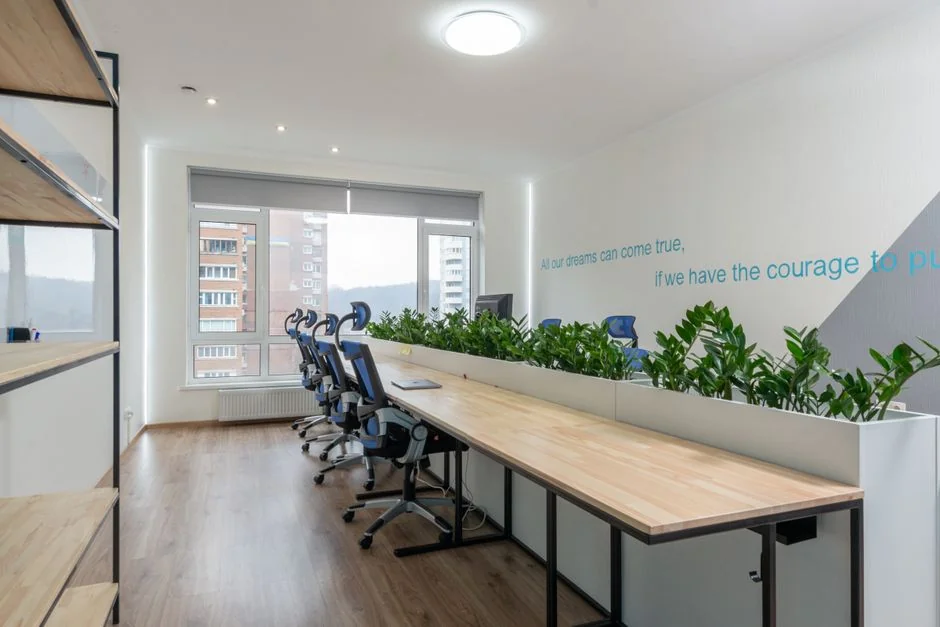 A sleek desk arrangement with a digital tablet, keyboard, camera, and plant, perfect for creative tasks.